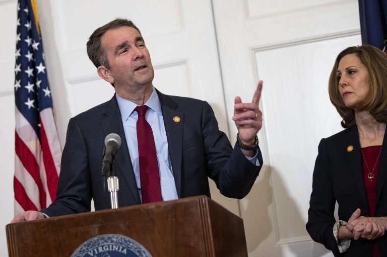 Virginia Gov. Ralph Northam, with his wife, Pam, speaks with reporters at a news conference Saturday in Richmond, Va.