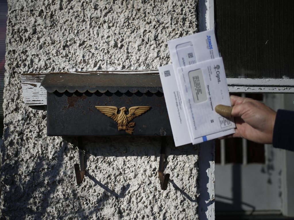 A U.S. Postal Service letter carrier delivers the mail in Shelbyville, Ky. A White House task force recommended ending the mailbox monopoly held by USPS. (Luke Sharrett/Bloomberg via Getty Images)