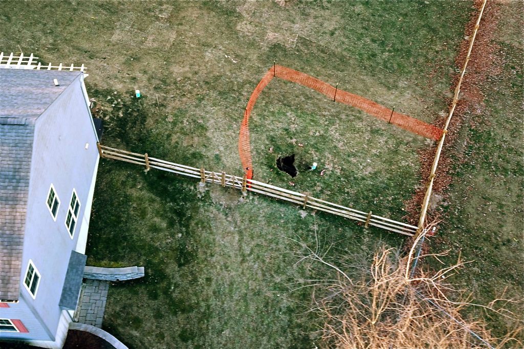 lisa_drive_drone_shot-e1548435221150-1920×998 A sinkhole that opened up in January outside a suburban home at Lisa Drive in West Whiteland Township, Chester County, is surrounded by orange plastic fencing.(Eric Friedman)
