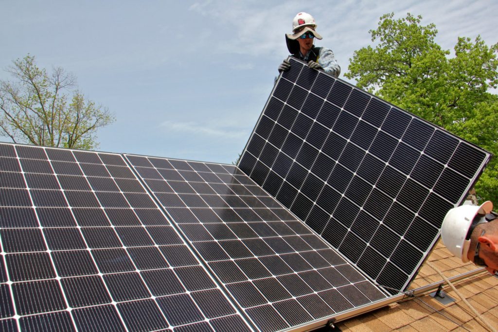 Patrick Whittaker of Solar States installs solar panels on the roof of a home in Bryn Mawr.