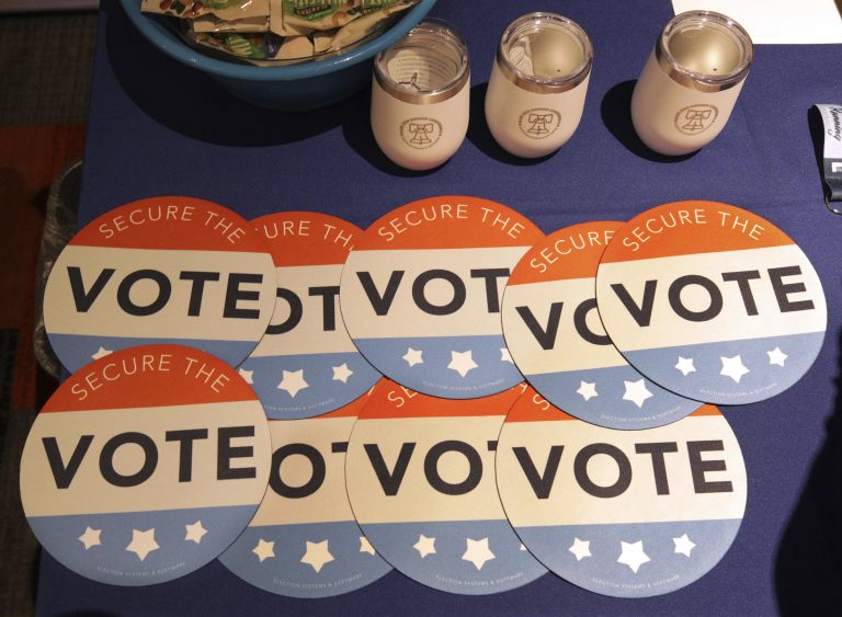 Computer mouse pads with Secure the Vote logo on them are seen on a vendor's table at a convention of state secretaries of state Saturday, July 14, 2018, in Philadelphia. (Mel Evans/AP Photo)