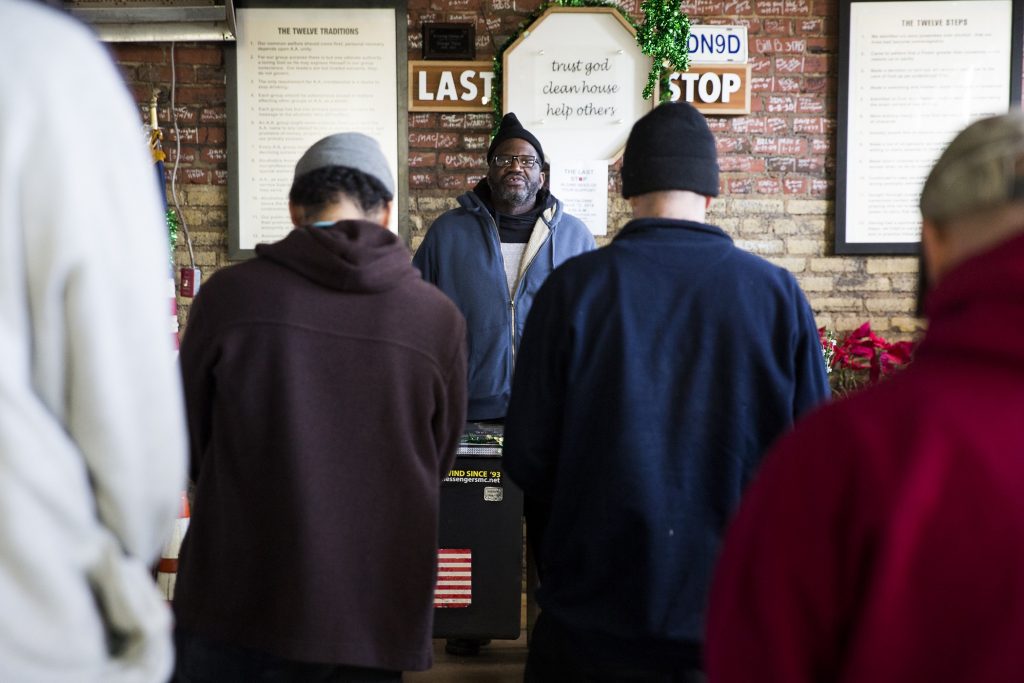 Nathanial McCray (center) leads the morning mediation at the Last Stop recovery center on Feb. 19, 2019. Meditation meetings encourage the center clients to remain mindful and present. McCray was picked to lead the meeting due to the positive example that he's set in his sobriety. A different client in good standing is picked to lead the meeting each morning. (Rachel Wisniewski for WHYY)