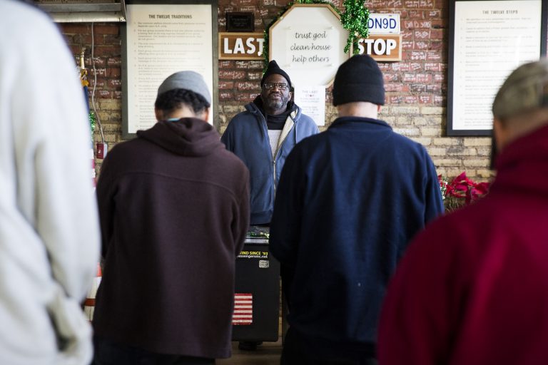 Nathanial McCray (center) leads the morning mediation at the Last Stop recovery center on Feb. 19, 2019. Meditation meetings encourage the center clients to remain mindful and present. McCray was picked to lead the meeting due to the positive example that he's set in his sobriety. A different client in good standing is picked to lead the meeting each morning. (Rachel Wisniewski for WHYY)