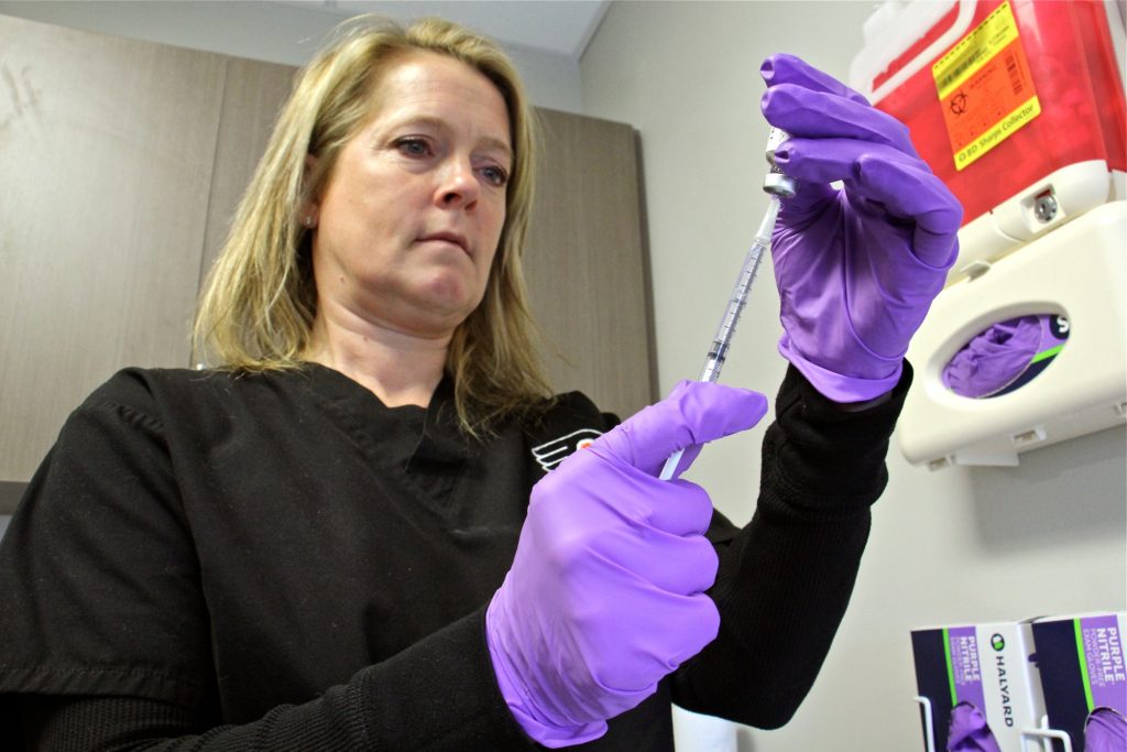 2019 03 15-e lee-nicole rodriguez-temple university student health-mumps outbreak Registered nurse Nicole Rodriguez draws a dose of mumps vaccine at the Temple student health center. (Emma Lee/WHYY)