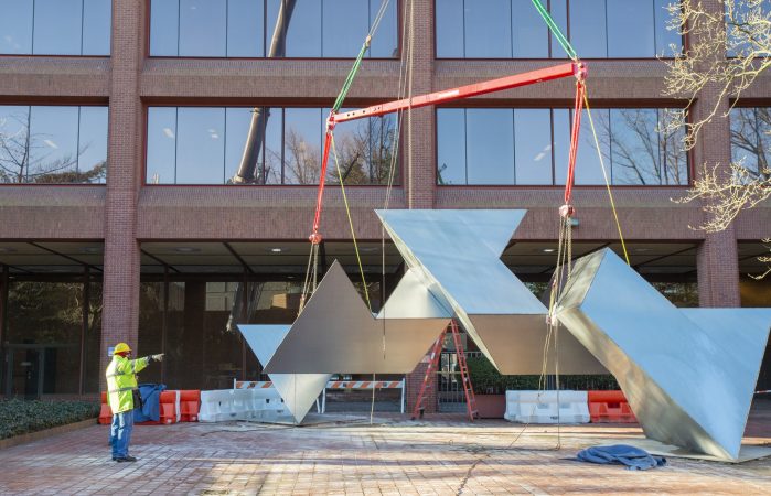 A workman makes final preparations to hoist the Whie Water sculpture. White Water, a sculpture by Philadelphia artist Robinson Fredenthal is moved from the garden behind the Wells Fargo building in Old City to its new home at the Woodmere Art Museum in Chestnut Hill. (Jonathan Wilson for WHYY)