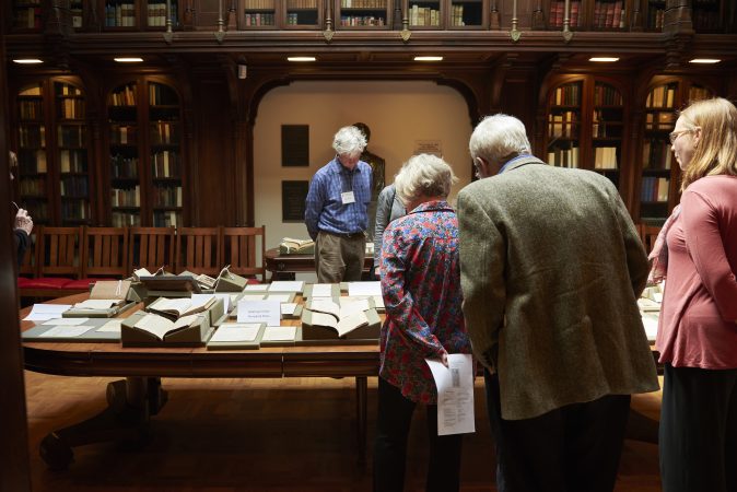 People gather to view a pop-up exhibit of drawings, photographs, manuscripts, books, and writings at Whitman at 200: Looking Back, Looking Forward a Symposium at the University of Pennsylvania in the Class of 1978 Orrery Pavilion, Van Pelt-Dietrich Library. (Natalie Piserchio for WHYY)