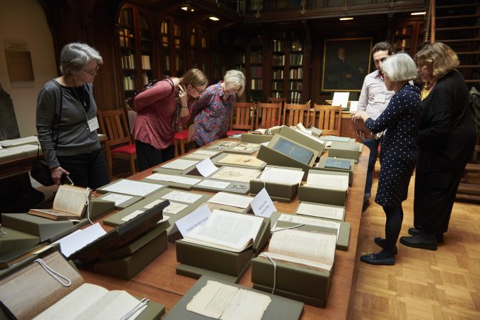 People gather to view a pop-up exhibit of drawings, photographs, manuscripts, books, and writings at Whitman at 200: Looking Back, Looking Forward a Symposium at the University of Pennsylvania in the Class of 1978 Orrery Pavilion, Van Pelt-Dietrich Library. (Natalie Piserchio for WHYY)