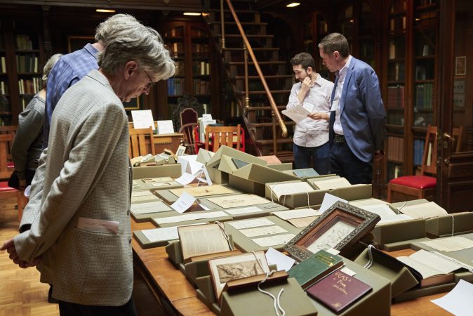 People gather to view a pop-up exhibit of drawings, photographs, manuscripts, books, and writings at Whitman at 200: Looking Back, Looking Forward a Symposium at the University of Pennsylvania in the Class of 1978 Orrery Pavilion, Van Pelt-Dietrich Library. (Natalie Piserchio for WHYY)