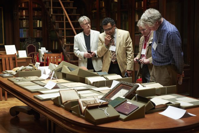 People gather to view a pop-up exhibit of drawings, photographs, manuscripts, books, and writings at Whitman at 200: Looking Back, Looking Forward a Symposium at the University of Pennsylvania in the Class of 1978 Orrery Pavilion, Van Pelt-Dietrich Library. (Natalie Piserchio for WHYY)