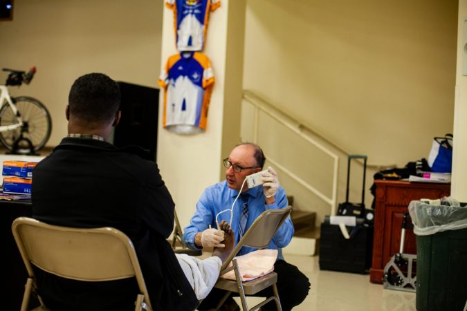 Dr. Ronald Renzi performs ultrasounds to check on blood circulation in screenings for Peripheral Vascular Disease. (Brad Larrison for WHYY)
