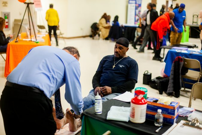 Dr. Ronald Renzi performs an ultrasound on Russell Davis to check on blood circulation in screenings for Peripheral Vascular Disease. (Brad Larrison for WHYY)