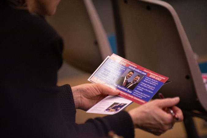 An attendee reviews materials put out by local government candidates during a forum hosted by the Montgomery County Republican Committee held at the Upper Merion Township Building in King of Prussia, Pa. on Thursday, February 28, 2019. (Kriston Jae Bethel for WHYY)