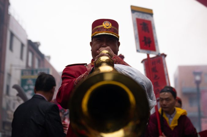 A man plays horn while participating in the Hoyu Folk Culture Festival parade in Chinatown on Sunday, March 31, 2019. (Kriston Jae Bethel for WHYY)