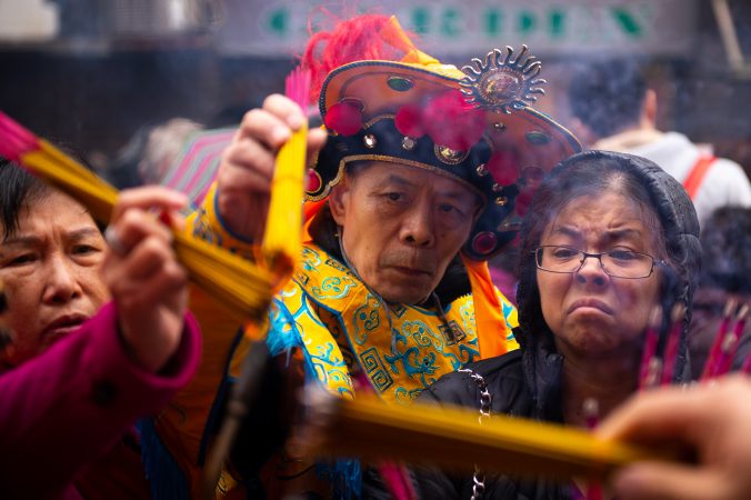Festival-goers light incense that they will use as an offering to honor their ancestors at the Hoyu Folk Culture Festival in Chinatown on Sunday, March 31, 2019. (Kriston Jae Bethel for WHYY)