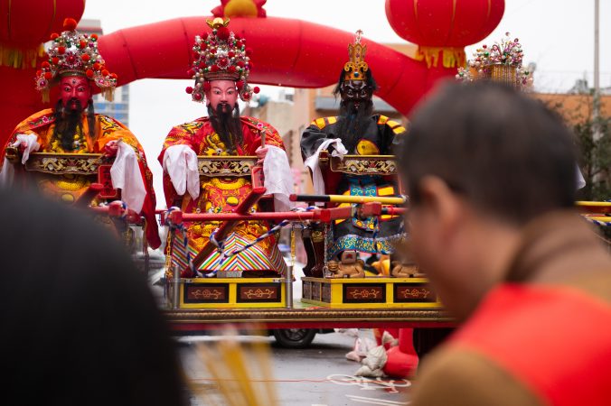 An effigy of General Humin is flanked by two others, as festival goers offer incense during the Hoyu Folk Culture Festival in Chinatown on Sunday, March 31, 2019. The festival celebrates the more than 1,000th birthday of General Humin, said to have been a scholar and a fighter, who helped build the city of Fuzhou. (Kriston Jae Bethel for WHYY)