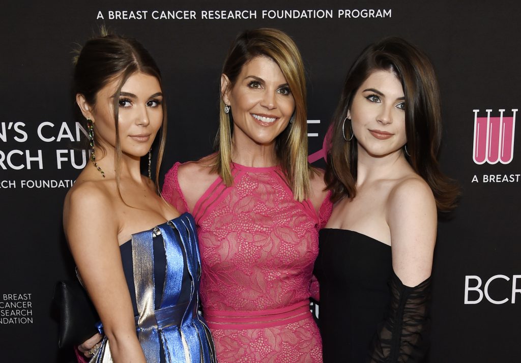 Lori Loughlin, Isabella Rose Giannulli, Olivia Jade Giannulli In this Feb. 28, 2019 file photo, actress Lori Loughlin, center, poses with daughters Olivia Jade Giannulli, left, and Isabella Rose Giannulli in Beverly Hills, Calif. Loughlin and her husband Mossimo Giannulli were charged along with nearly 50 other people Tuesday in a scheme in which wealthy parents bribed college coaches and other insiders to get their children into some of the most elite schools in the country, federal prosecutors said. (Photo by Chris Pizzello/Invision/AP, File)