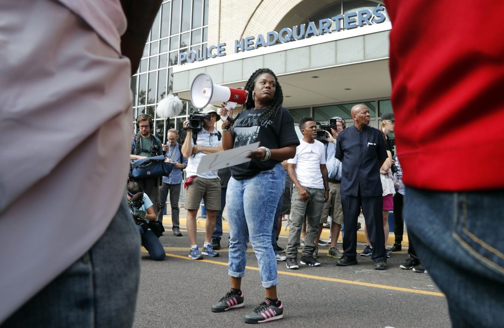 Ferguson Activists Deaths In this Sept. 17, 2017 file photo, Cori Bush speaks on a bullhorn to protesters outside the St. Louis Police Department headquarters in St. Louis. Six deaths, all involving men with connections to protests in Ferguson, Missouri, drew attention on social media and speculation in the activist community that something sinister was at play. Bush said her car has been run off the road, her home has been vandalized, and in 2014 someone shot a bullet into her car, narrowly missing her daughter, who was 13 at the time. Activists and observers remain puzzled, especially since people involved in the protests continue to face harassment and threats. (Jeff Roberson/AP Photo)