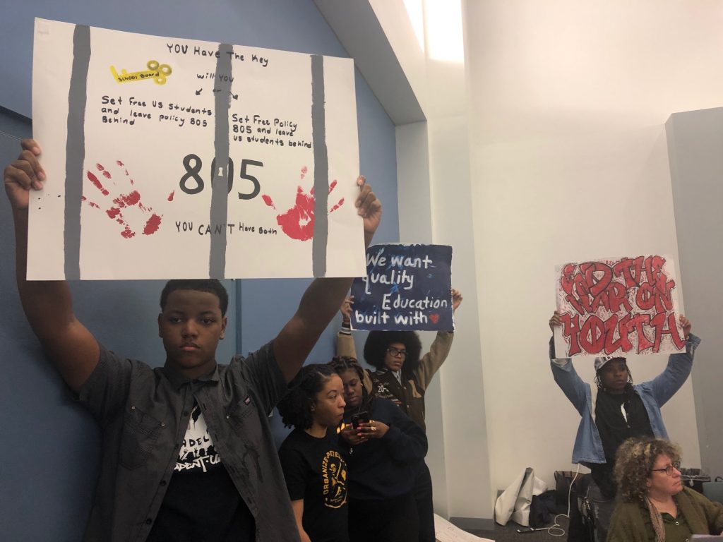 IMG_2541 Students hold up signs denouncing Policy 805 prior to the Board’s yes vote that led students and faculty to temporarily shut down the school board meeting. (Darryl Murphy/WHYY)