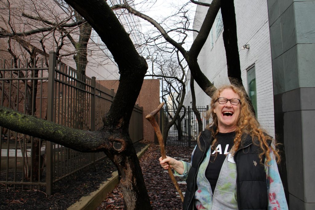 2019 03 22-e lee-sally mccabe-philadelphia whyy-spring blooming trees This Eastern redbud tree outside WHYY studios will bloom in a few weeks, and that thought delights Sally McCabe, associate director of community education at the Pennsylvania Horticultural Society. (Emma Lee/WHYY)