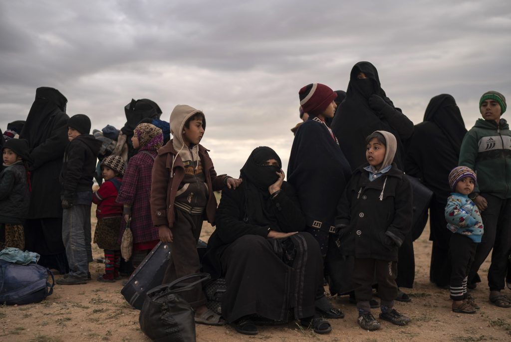 Women and children evacuated out of the last territory held by Islamic State militants wait to be screened by U.S.-backed Syrian Democratic Forces (SDF) in the desert outside Baghouz, Syria, on Feb. 27. A Humvee drives in a village recently retaken from Islamic State militants by U.S.-backed Syrian Democratic Forces (SDF) near Baghouz, on Feb. 17.
(Felipe Dana/AP Photo)