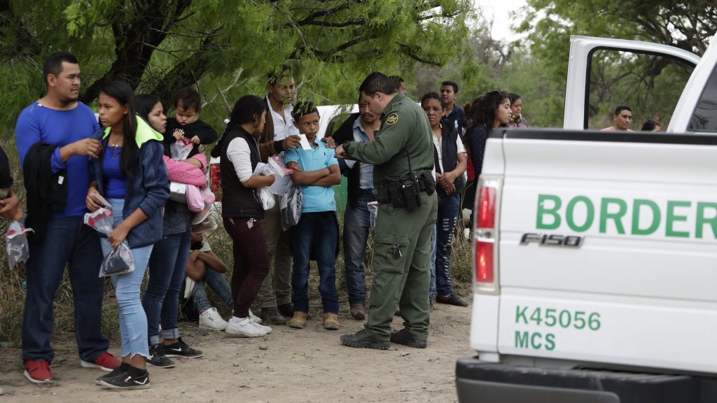 A Border Patrol agent checks the names and documents of families who crossed the nearby U.S.-Mexico border near McAllen, Texas. Immigration authorities say they expect the continuing surge of Central American families crossing the border to multiply in the coming months. (Eric Gay/AP Photo)