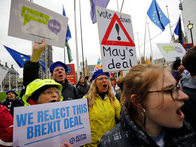 Anti-Brexit activists hold placards and wave flags as they demonstrate outside the Houses of Parliament in London on Tuesday, ahead of a crucial vote on Prime Minister Theresa May's Brexit deal. (Tolga Akmen/AFP/Getty Images)