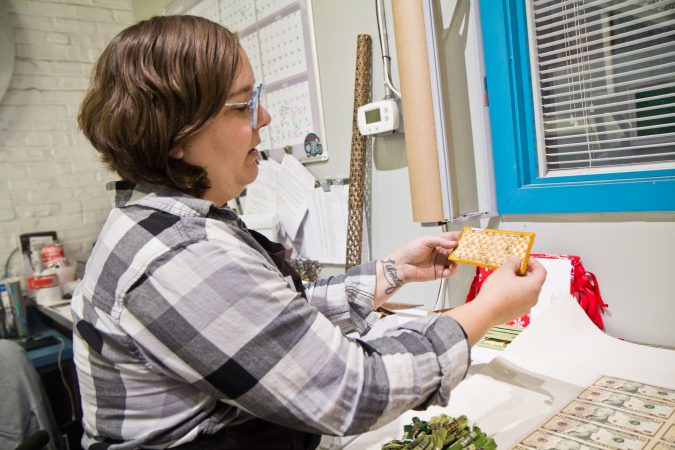Jewelry maker and sculpture artist Stacey Lee Webber shows an embroidery work in progress. (Kimberly Paynter/WHYY)