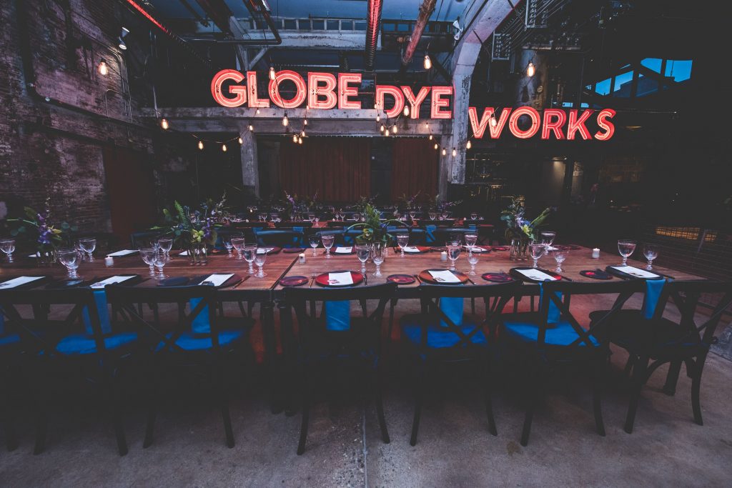 the-original-globe-dye-works-sign-now-takes-center-stage-in-the-boiler-room-credit-birchtree-catering-beaumonde-originals.original The original Globe Dye Works sign now takes center stage in the former boiler room. (Courtesy of Birchtree Catering/BeauMonde Originals)