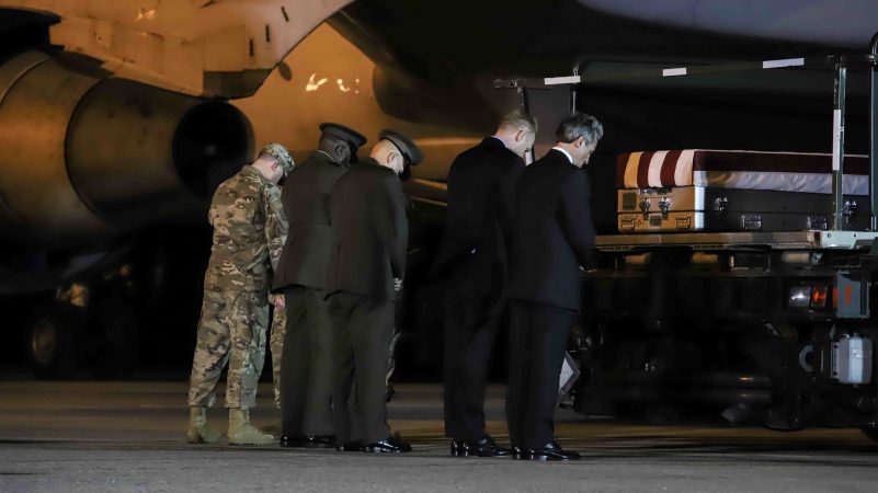 Delaware Governor John Carney prays in front of the transfer case of Staff Sgt. Christopher K.A. Slutman, 43, of Newark, Delaware, during a dignified transfer at Dover Air Force Base Thursday, Apr. 11, 2019,  in Dover, Del. (Saquan Stimpson for WHYY)Sgt. Slutman died April 8 while conducting combat operations in Parwan province, Afghanistan.