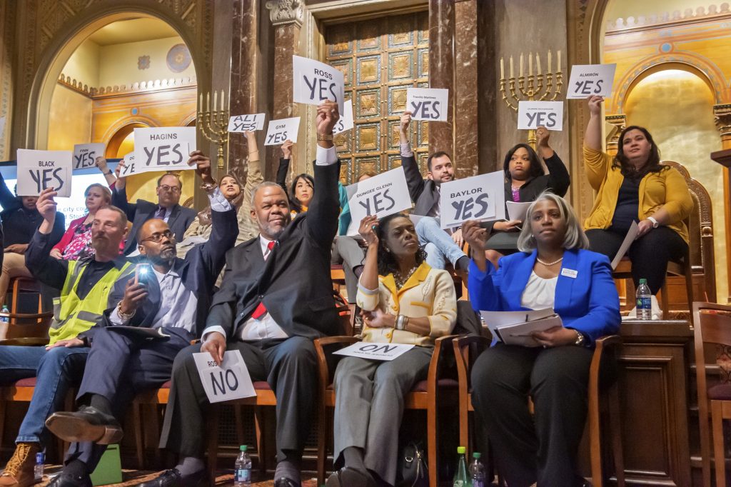 2019 03 24-j wilson-philadelphia congregation rodeph shalom-candidates forum at large city council Candidates hold yes signs aloft signaling their agreement with the proposal of a representative speaker. Twenty candidates for city council attended a candidates forum at Congregation Rodeph Shalom on March 24, 2019. (Jonathan Wilson for WHYY)