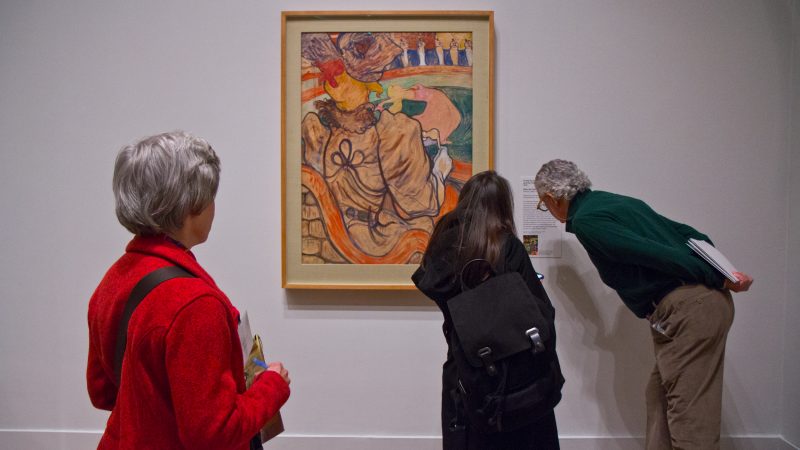 Visitors admire Henri de Toulouse-Lautrec’s “The Dancer and the Five Stiff Shirts” at “The Impressionist’s Eye” exhibit at the Philadelphia Museum of Art. (Kimberly Paynter/WHYY)
