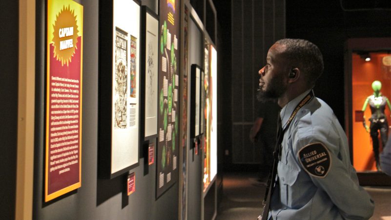 A security guard at the Franklin Institute pauses to take in some of the Marvel Comics exhibit. The more than 300 objects in the sprawling exhibit have an insured value of more than $25 million, according to curator Ben Saunders. (Emma Lee/WHYY)
