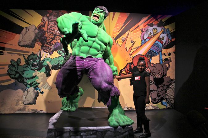 Tiana Sirmans of New Castle, Delaware, poses with The Incredible Hulk during a preview of the Marvel Comics exhibit at the Franklin Institute. (Emma Lee/WHYY)