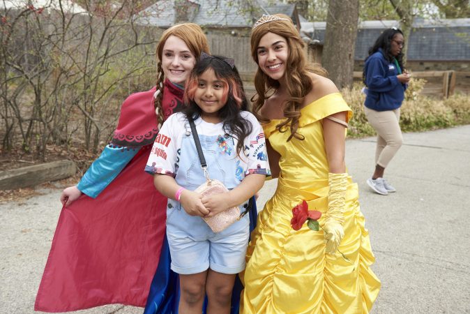 Yancy Estrada, 9, poses with Caroline Nowak as Snow White and Nicole Gonzales as Bell, at the 20th annual Autism Awareness Day at the Philadelphia Zoo. (Natalie Piserchio for WHYY)