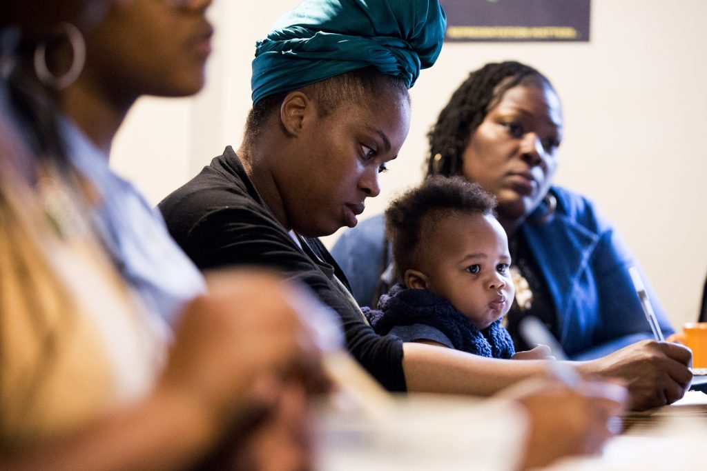 2019 04 15 – r wisniewski – Laura Walker Thaashae Reingoud Amir Reingoud Juanita AbdulAliy – philadelphia kensington franny lous porch – lets doula this workshop Thaashae Reingoud (center) takes notes as her son, Amir, sits on her lap at the