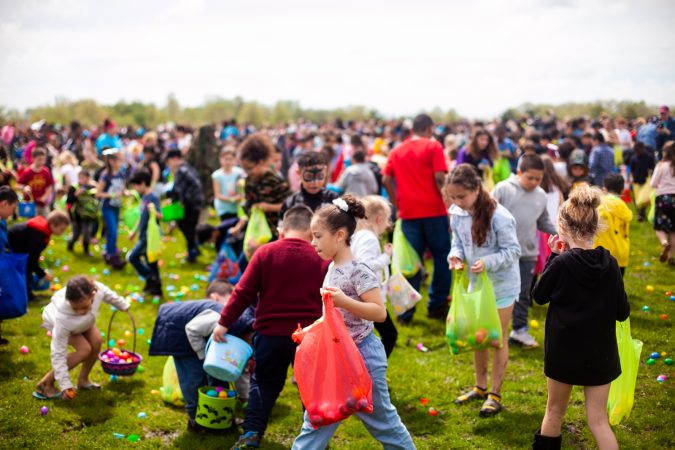 Children search for Easter eggs at the River Fields in Northeast Philadelphia Saturday after a helicopter dropped an estimated 30,000 eggs. (Brad Larrison for WHYY)