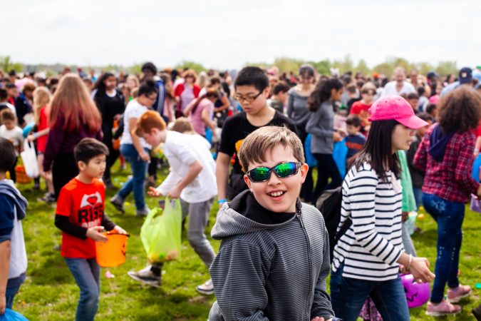 Children search for Easter eggs at the River Fields in Northeast Philadelphia Saturday after a helicopter dropped an estimated 30,000 eggs. (Brad Larrison for WHYY)