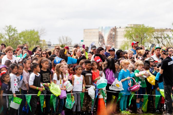 Children wait for the arrival of a helicopter that would drop thousands of Easter eggs on the River Fields in Northeast Philadelphia Saturday. (Brad Larrison for WHYY)