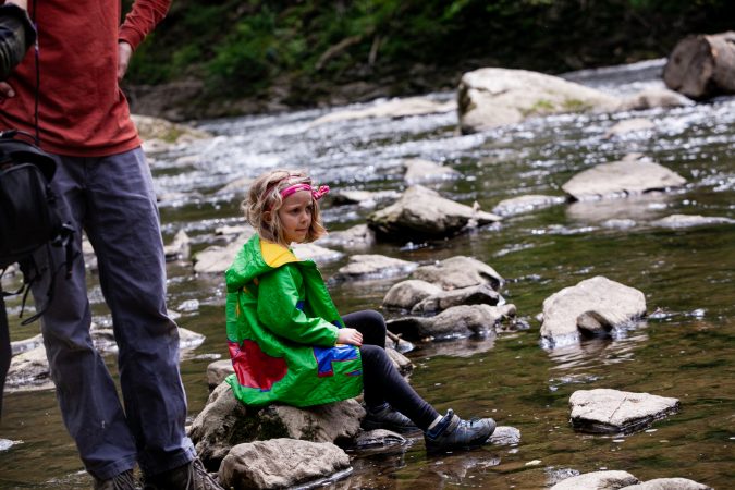 Five-year-old Ellie Sponsler sits on a rock looking for wildlife during the City Nature Challenge Sunday. (Brad Larrison for WHYY)