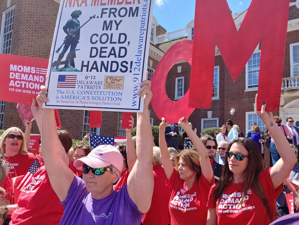 20190410_123024_HDR An NRA supporter holds up a sign in front of gun-control activists in front of the Delaware State Capitol building in Dover, Del., Wednesday. (Zoe Read/WHYY)
