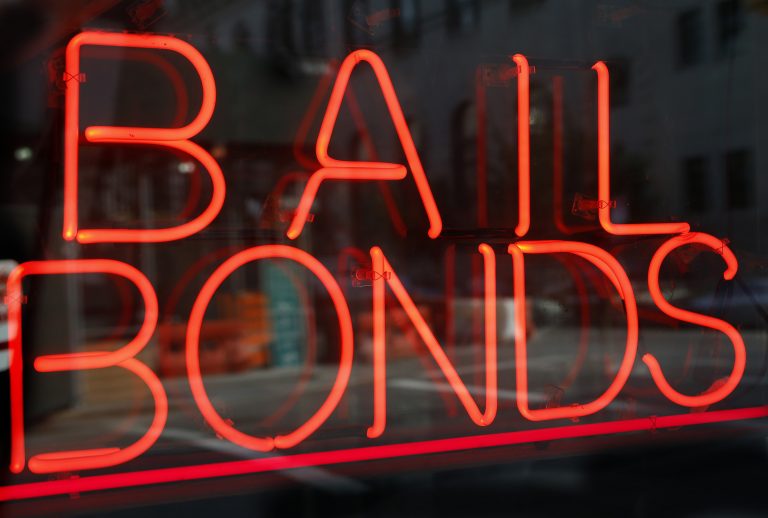 In this Tuesday, July 7, 2015, file photo, a sign advertising a bail bonds business is displayed near a jail and courthouse complex (Kathy Willens/AP Photo, File)