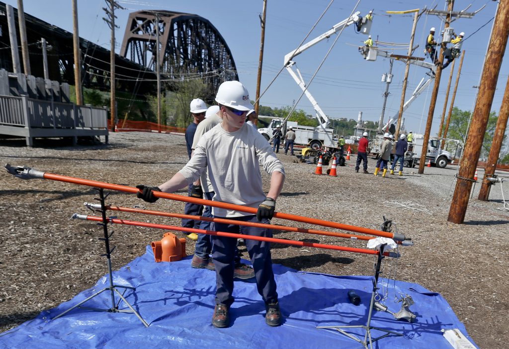 Lineworker Training Pennsylvania A student at the Duquesne Light Co. lineworker training center takes a high voltage hot stick to others learning the trade in Pittsburgh on Wednesday, May 9, 2018. They are taking part in a partnership training program with the Community College of Allegheny County. John Andzelik, the manager of workforce develpment for Duquesne light, said that people in the program range from recent high school graduates to older people looking for a career change. (AP Photo/Keith Srakocic)
