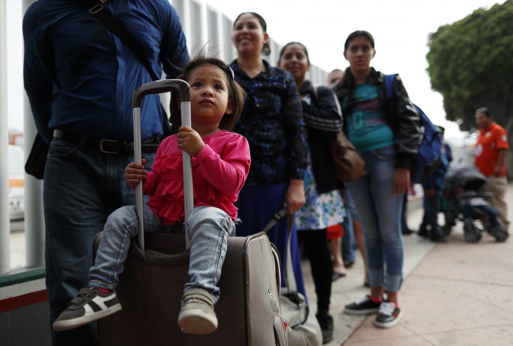 Merari Calderon, of El Salvador, lines up with her father, Alexander Calderon, left, to cross into the U.S. to begin the process of applying for asylum Thursday, July 26, 2018, near the San Ysidro port of entry in Tijuana, Mexico (Gregory Bull/AP Photo)