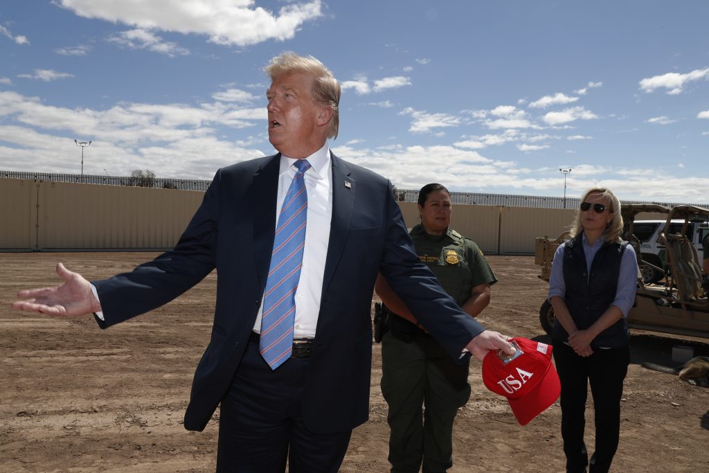 President Donald Trump visits a new section of the border wall with Mexico in Calexico, Calif., Friday April 5, 2019. Gloria Chavez with the U.S. Border Patrol, center, and Homeland Security Secretary Kirstjen Nielsen listen. (Jacquelyn Martin/AP Photo)