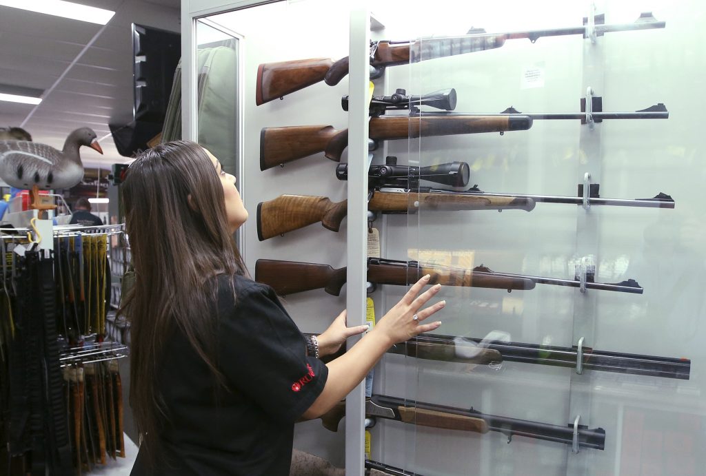 NRA Overseas In this Wednesday, Oct. 4, 2017 file photo, a salesperson checks rifles in a gun shop display in Sydney, Australia. A documentary aired in March 2019 by Al Jazeera reported officials with Australia's far-right One Nation party met with two National Rifle Association representatives and other gun-rights advocates seeking money to undermine Australian gun laws. (Rick Rycroft/AP Photo)