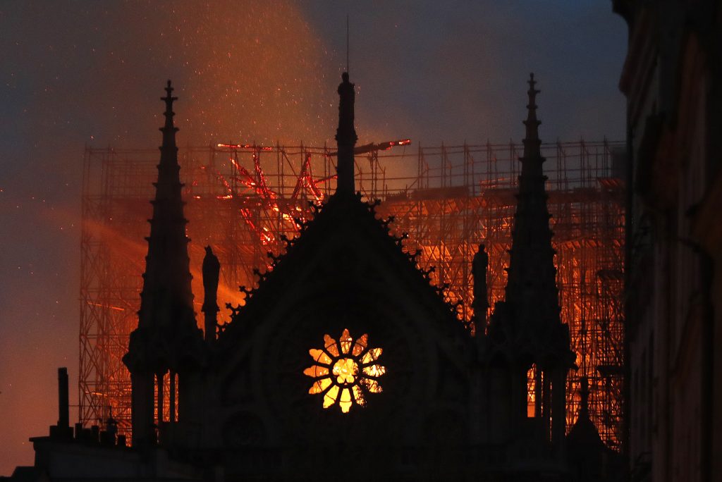 APTOPIX France Notre Dame Fire Flames and smoke rise from Notre Dame cathedral as it burns in Paris, Monday, April 15, 2019. Massive plumes of yellow brown smoke filled the air above Notre Dame Cathedral and ash fell on tourists and others around the island that marks the center of Paris. (Thibault Camus/AP Photo)