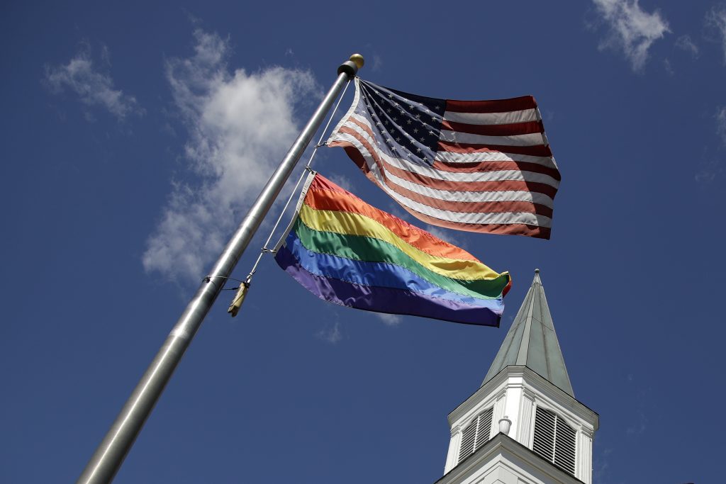Disunited Methodists A gay pride rainbow flag flies along with the U.S. flag. (Charlie Riedel/AP Photo)