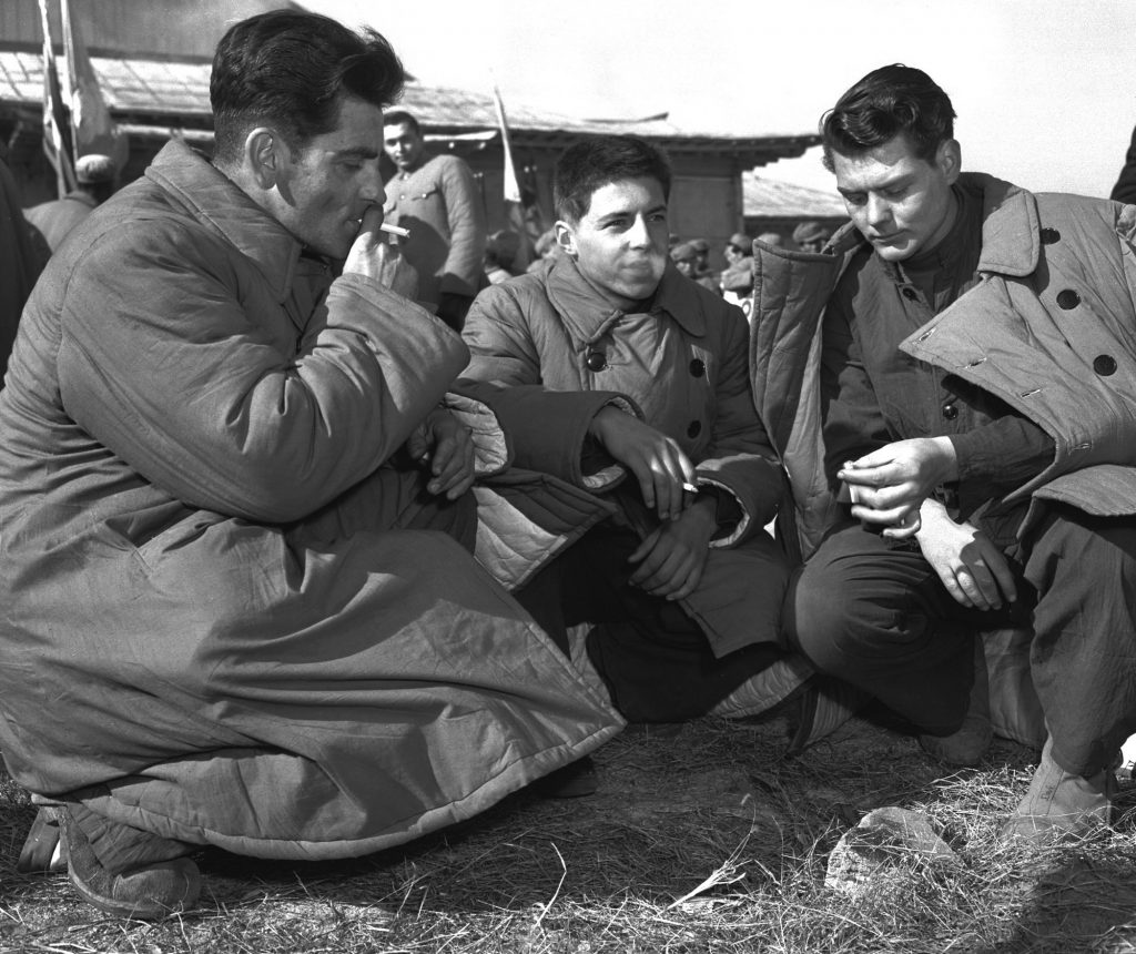 DEFECTORS In this January 1954 file photo, three Americans who refused repatriation, take a smoke break outside the peace hut at Panmunjom, Korea. They were among 21 U.S. prisoners of war who refused to come home after the Korean War. The new PBS documentary
