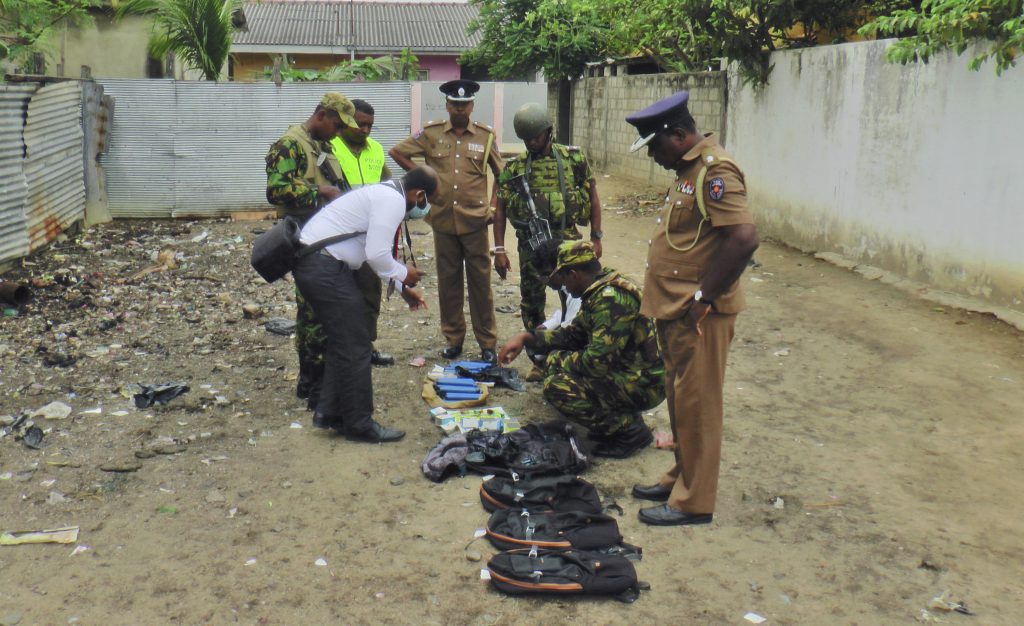 Sri Lankan police and army officers display gelatin sticks, detonators, back packs and other bomb making material recovered from the hide out of militants after Friday's gun battle in Kalmunai, in eastern Sri Lanka Sri Lanka, Saturday, April 27, 2019. Militants linked to Easter suicide bombings opened fire and set off explosives during a raid by Sri Lankan security forces on a house in the country's east, leaving behind 15 bodies, including six children. (Achala Upendra/AP Photo)