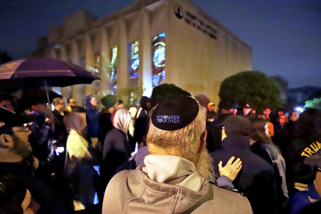 Synagogue Shooting California Pittsburgh A group gathers outside the Tree of Life Synagogue for a vigil to honor the victims of the Saturday attack on synagogue in California Saturday April 27, 2019 in the Squirrel Hill neighborhood of Pittsburgh. It is six months to the day that a gunman shot and killed 11 people while they worshipped at the Tree of Life Synagogue on Oct. 27, 2018. (AP Photo/Gene J. Puskar)
